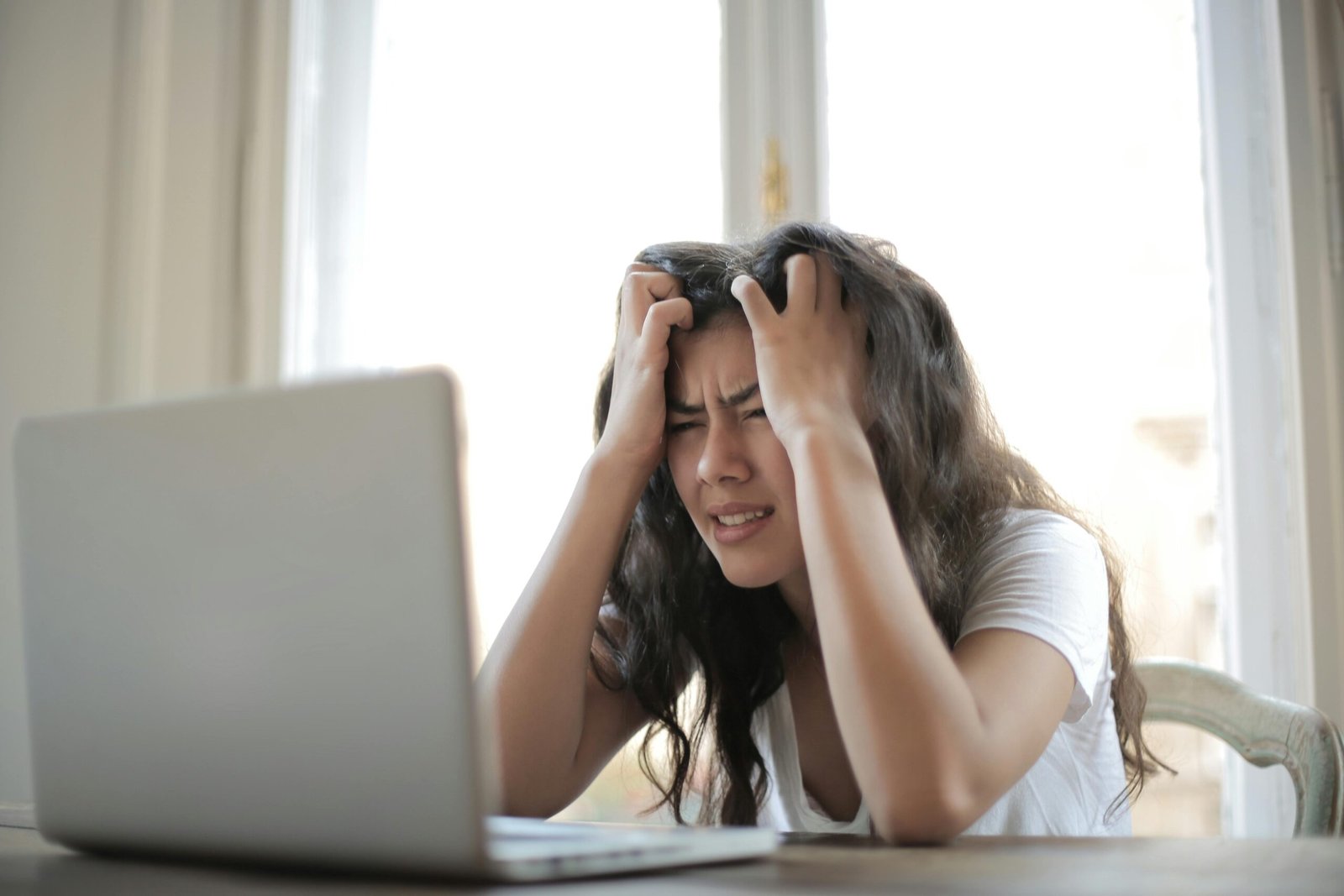 pexels-photo-3807738-3807738 Frustrated woman struggling with remote work stress and digital challenges indoors.