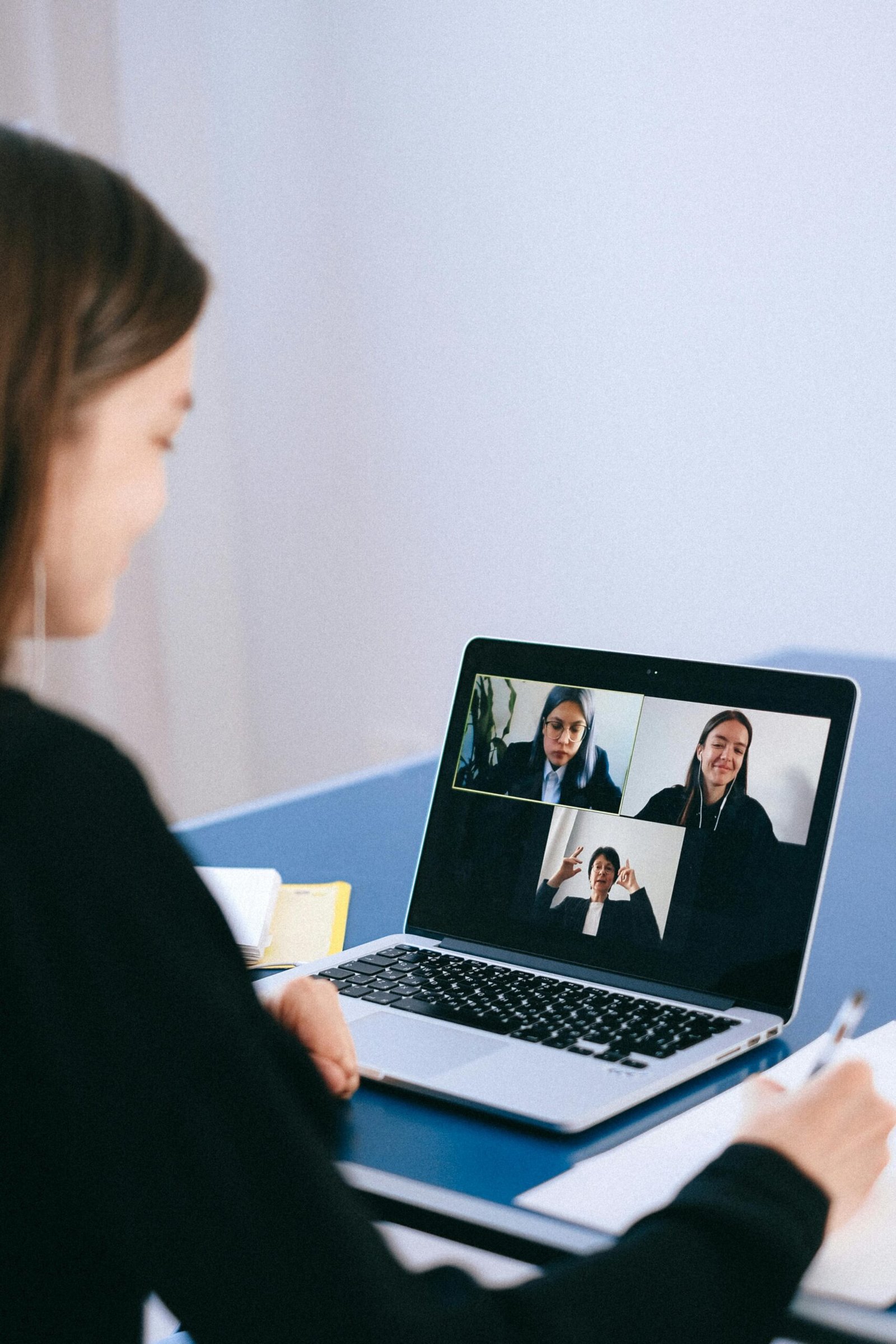 pexels-photo-4226122-4226122 A woman participates in a virtual meeting with colleagues via video call on a laptop.